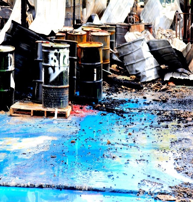 Oil drums with spilled oil on the ground